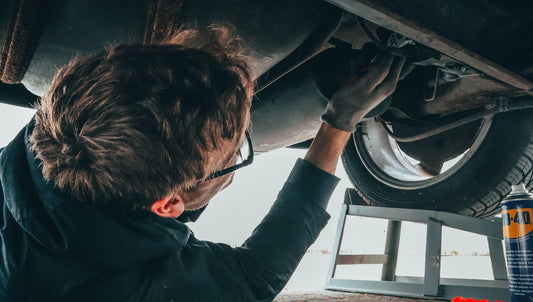 Technician installing shield on vehicle